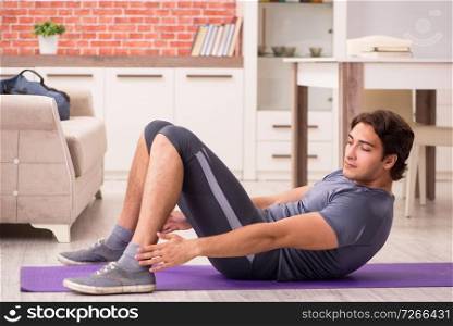 Young handsome man doing sport exercises at home  . Young handsome man doing sport exercises at home 