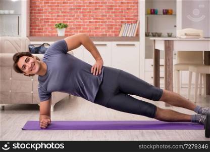 Young handsome man doing sport exercises at home . Young handsome man doing sport exercises at home