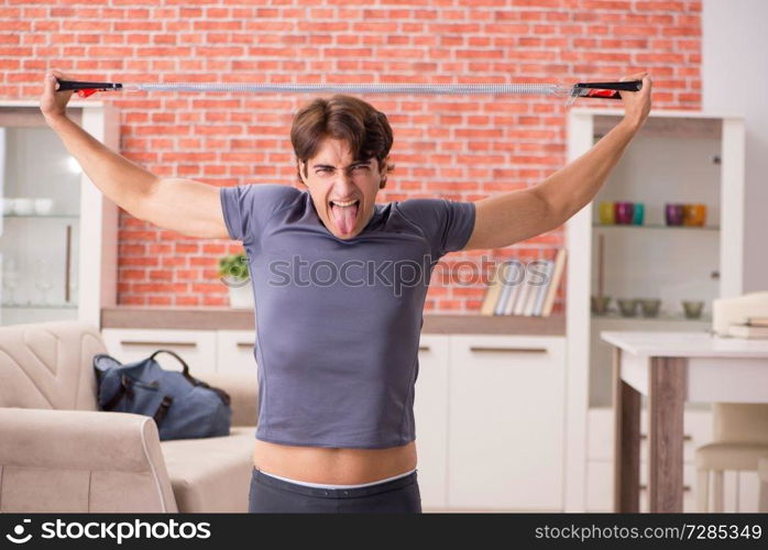 Young handsome man doing sport exercises at home  . Young handsome man doing sport exercises at home 
