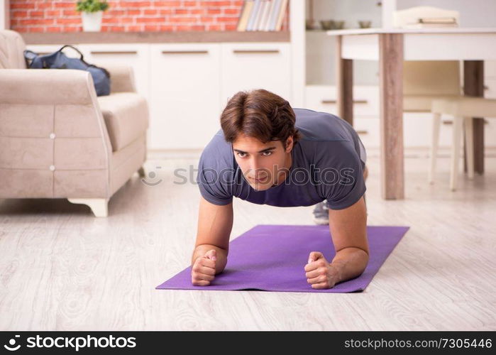 Young handsome man doing sport exercises at home  . Young handsome man doing sport exercises at home 