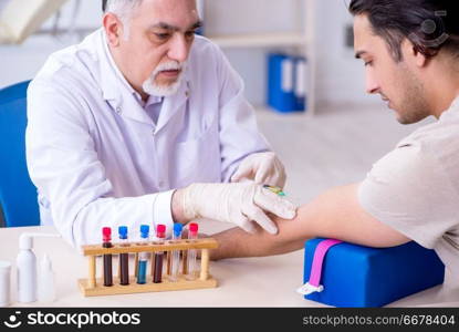 Young handsome man during blood test s&ling procedure 