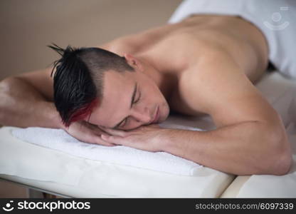 young handsome man have relaxing massage in spa and wellness salon