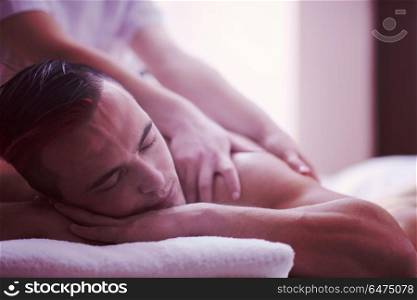 young handsome man have relaxing massage in spa and wellness salon. man have relaxing massage