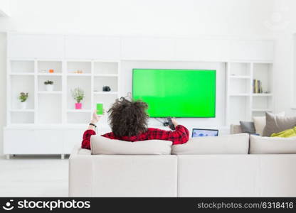 young handsome man in bathrobe enjoying free time watching television in his luxury home