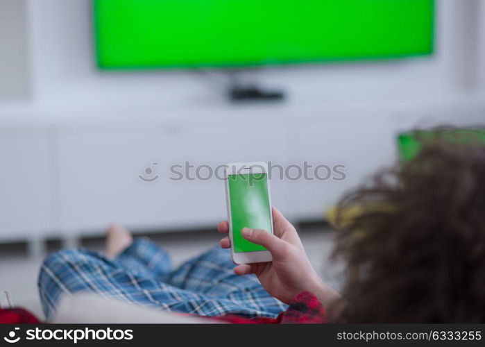 young handsome man in bathrobe enjoying free time watching television in his luxury home