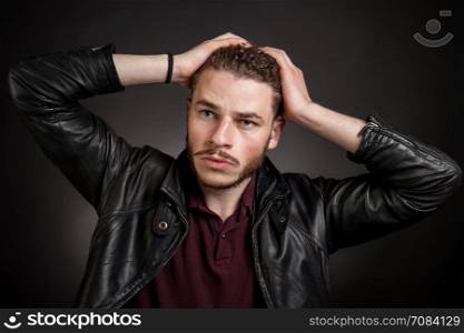 Young handsome man in black leather jacket looking aside