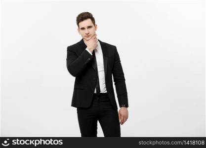 Young handsome man in black suit and glasses looking at copy-space thinking or dreaming isolated over white background.. Young handsome man in black suit and glasses looking at copy-space thinking or dreaming isolated over white background