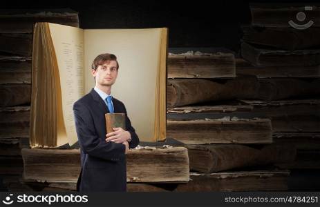Young handsome man in suit reading old book. Elevate your mind