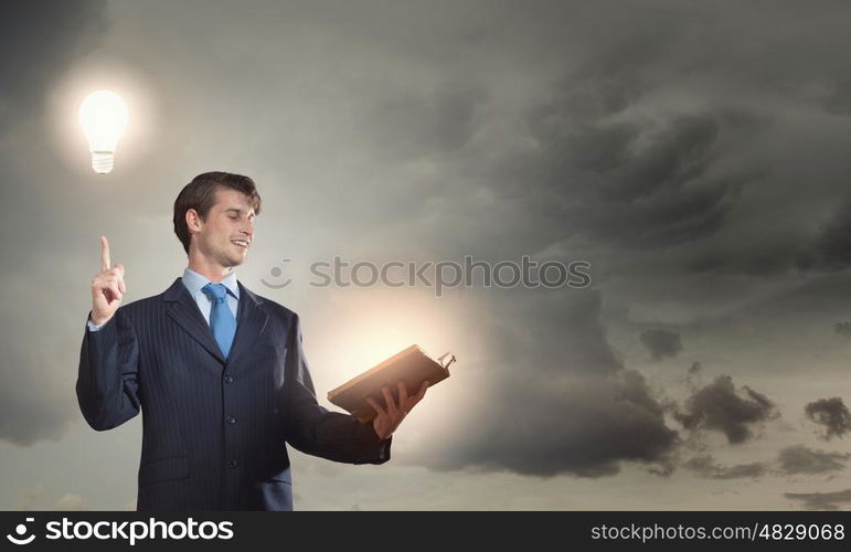 Young handsome man in suit reading old book. Elevate your mind