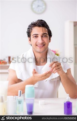 Young handsome man in the bathroom in hygiene concept 