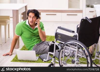 Young handsome man in wheelchair at home 