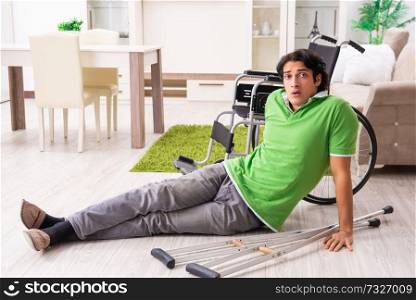 Young handsome man in wheelchair at home 