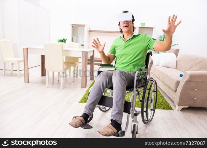 Young handsome man in wheelchair at home 