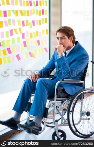 Young handsome man in wheelchair with many conflicting priorities . The young handsome man in wheelchair with many conflicting priorities 