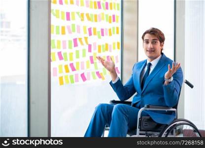 Young handsome man in wheelchair with many conflicting priorities . Young handsome man in wheelchair with many conflicting prioritie