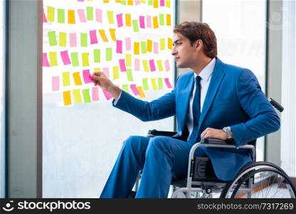Young handsome man in wheelchair with many conflicting priorities . Young handsome man in wheelchair with many conflicting prioritie
