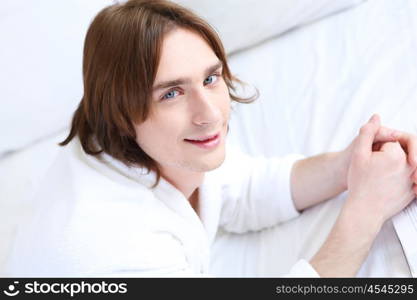 young handsome man lying in a bed at home