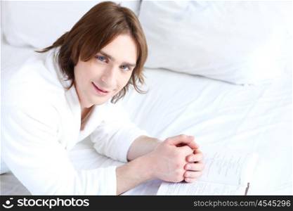 young handsome man lying in a bed at home
