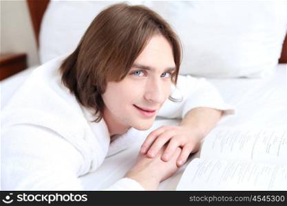 young handsome man lying in a bed at home