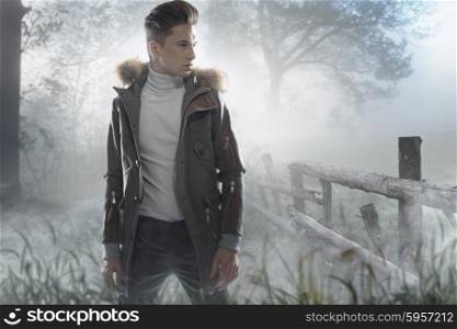 Young handsome man on the frozen county meadow