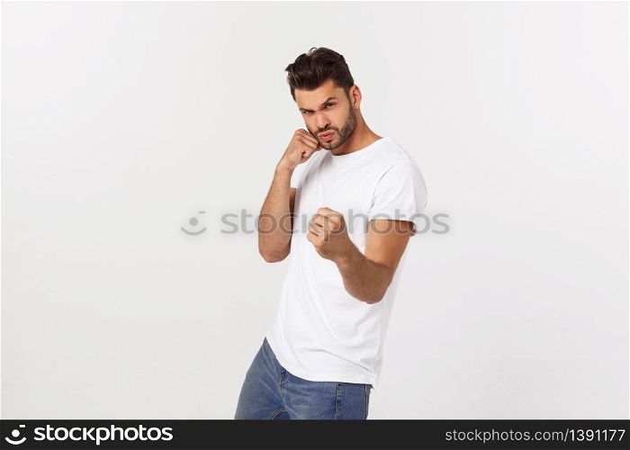 Young handsome man over isolated background Punching fist to fight, aggressive and angry attack, threat and violence.. Young handsome man over isolated background Punching fist to fight, aggressive and angry attack, threat and violence