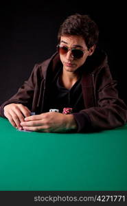 Young handsome man playing texas hold&acute;em poker