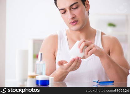 Young handsome man shaving early in the morning at home