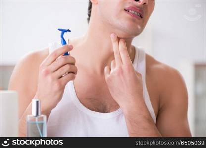 Young handsome man shaving early in the morning at home