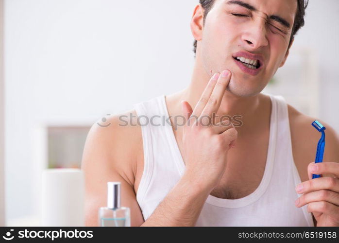 Young handsome man shaving early in the morning at home