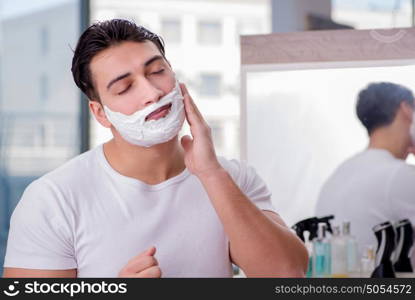 Young handsome man shaving in the morning