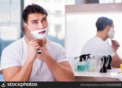 Young handsome man shaving in the morning