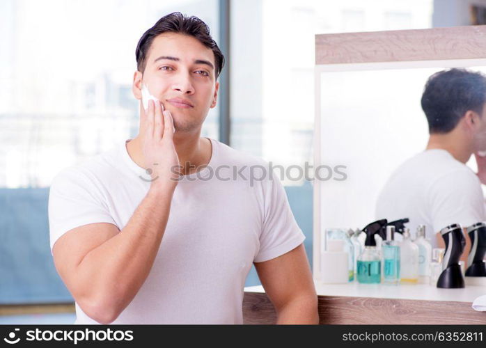 Young handsome man shaving in the morning