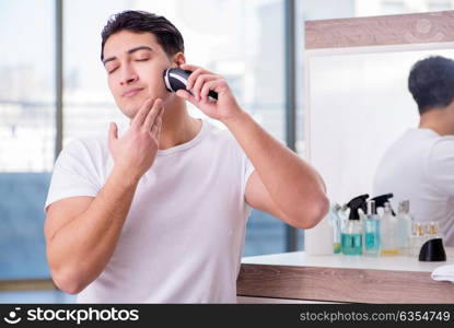 Young handsome man shaving in the morning