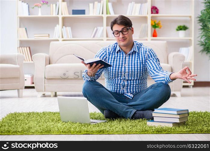 Young handsome man sitting on floor at home