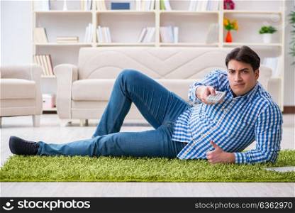 Young handsome man sitting on floor at home
