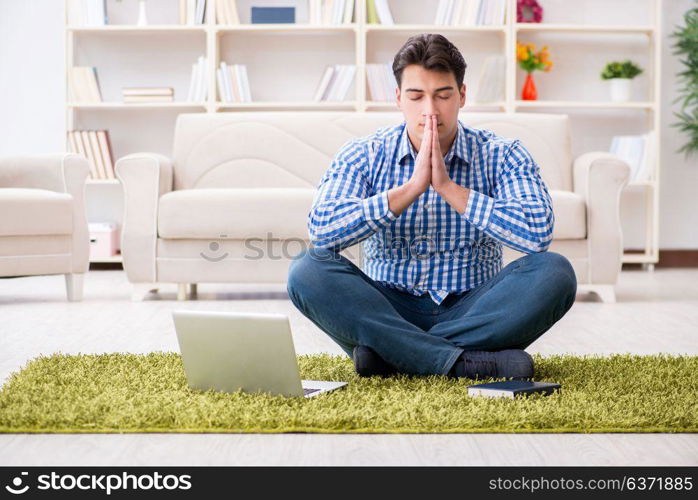 Young handsome man sitting on floor at home