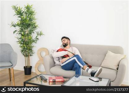 young handsome man sleeping sofa with his baby hand home