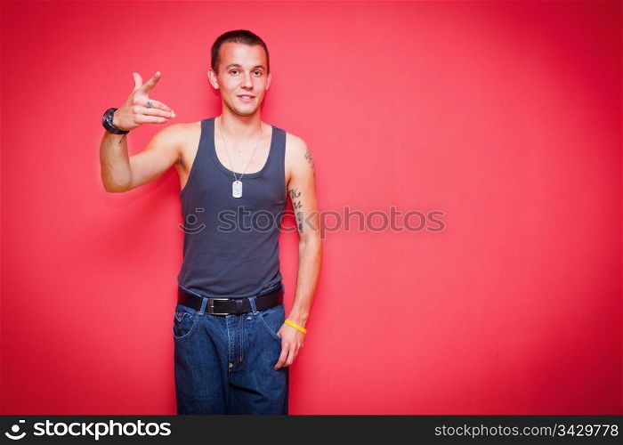 Young handsome man standing in a sexy pose on red background