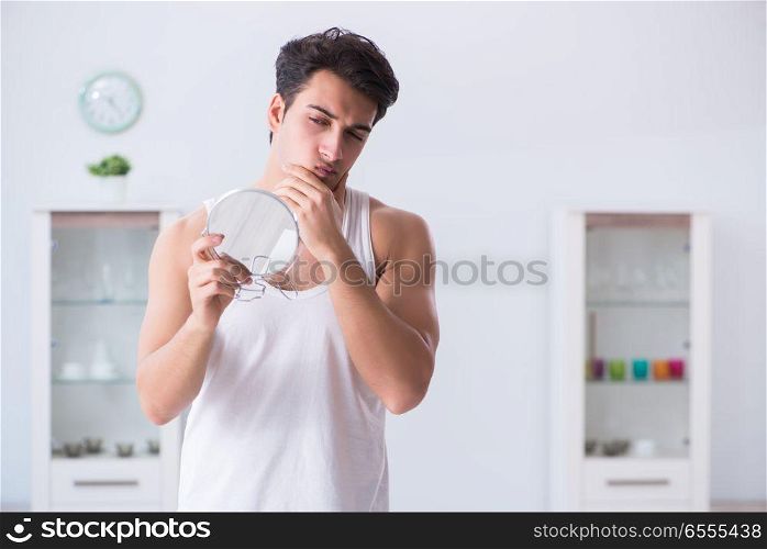 Young handsome man staring in the mirror