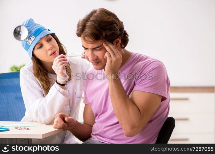 Young handsome man visiting young female doctor otolaryngologist