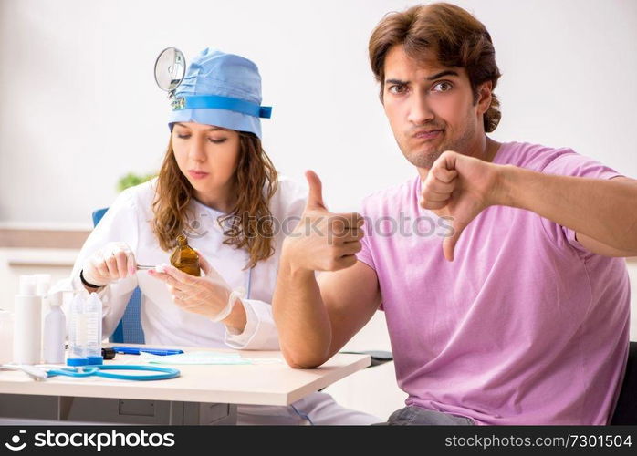 Young handsome man visiting young female doctor otolaryngologist