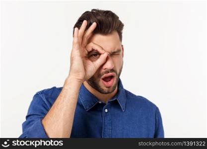 Young handsome man with beard doing ok gesture shocked with surprised face, eye looking through fingers. Unbelieving expression. Young handsome man with beard doing ok gesture shocked with surprised face, eye looking through fingers. Unbelieving expression.