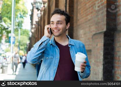 Young handsome man with disposable coffee. Take away concept. Outdoors