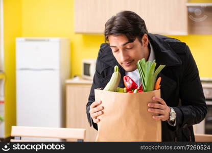 Young handsome man with vegetables in kitchen  