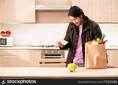 Young handsome man with vegetables in the kitchen 