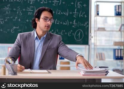 Young handsome math teacher in classroom 