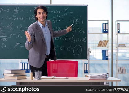 Young handsome math teacher in classroom 