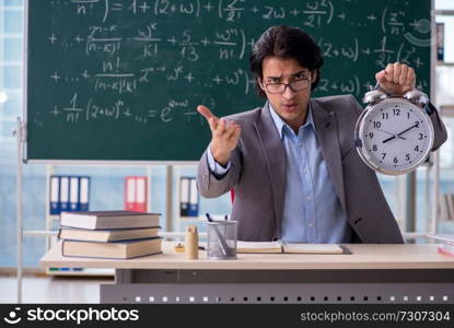 Young handsome math teacher in classroom 