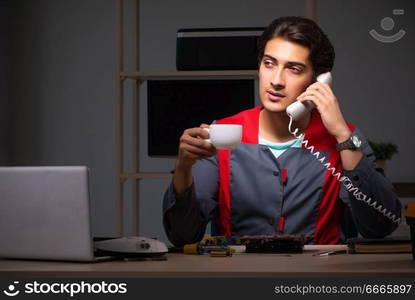 Young handsome repairman repairing computer 