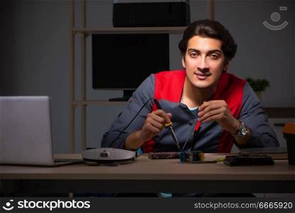 Young handsome repairman repairing computer 